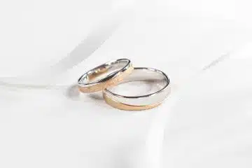 two wedding rings sitting on top of a white cloth